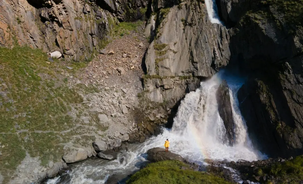Готовый туристический маршрут по Дагестану с горным водопадом и путешественником у подножия скал